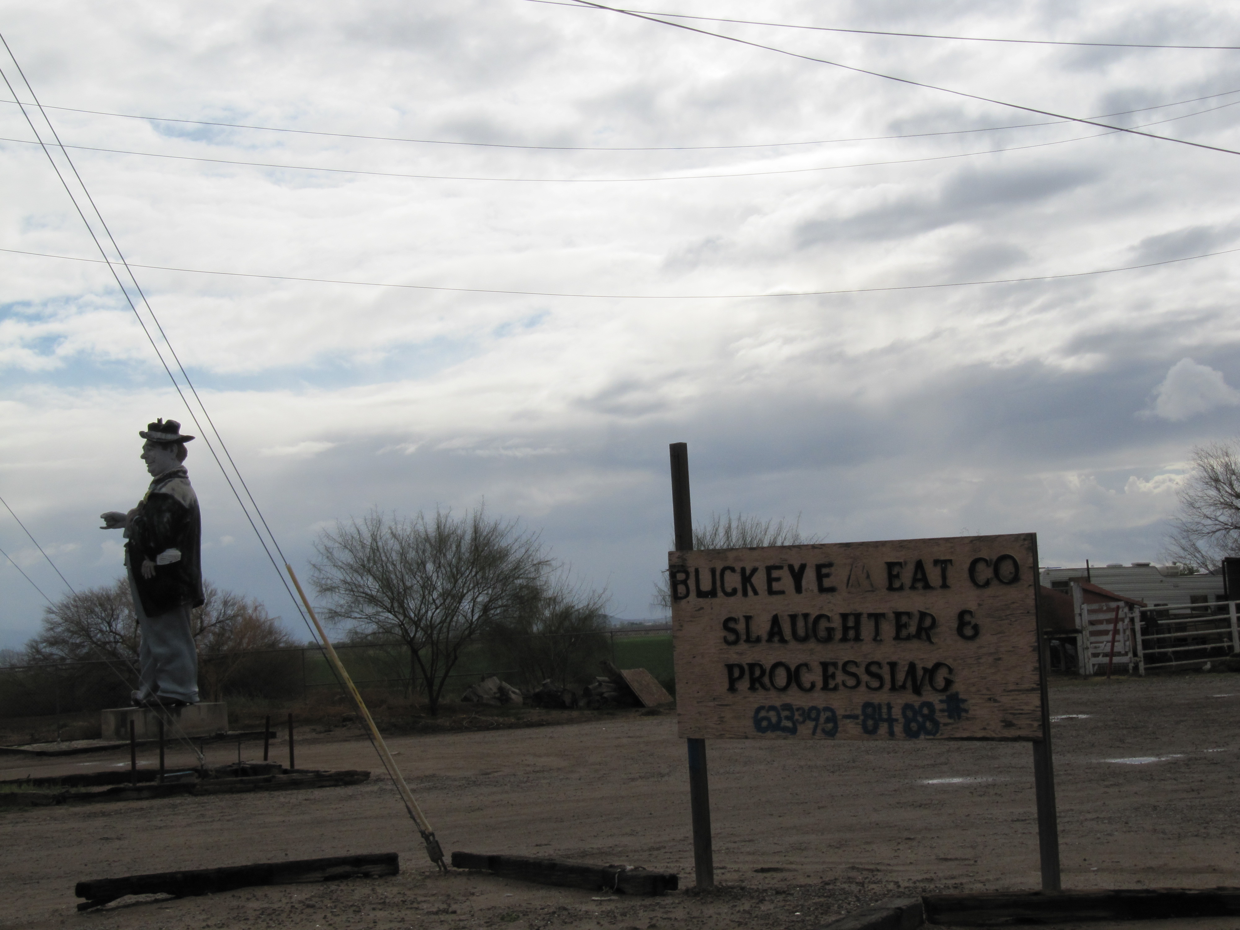 Joe stands near the meat processing facility.