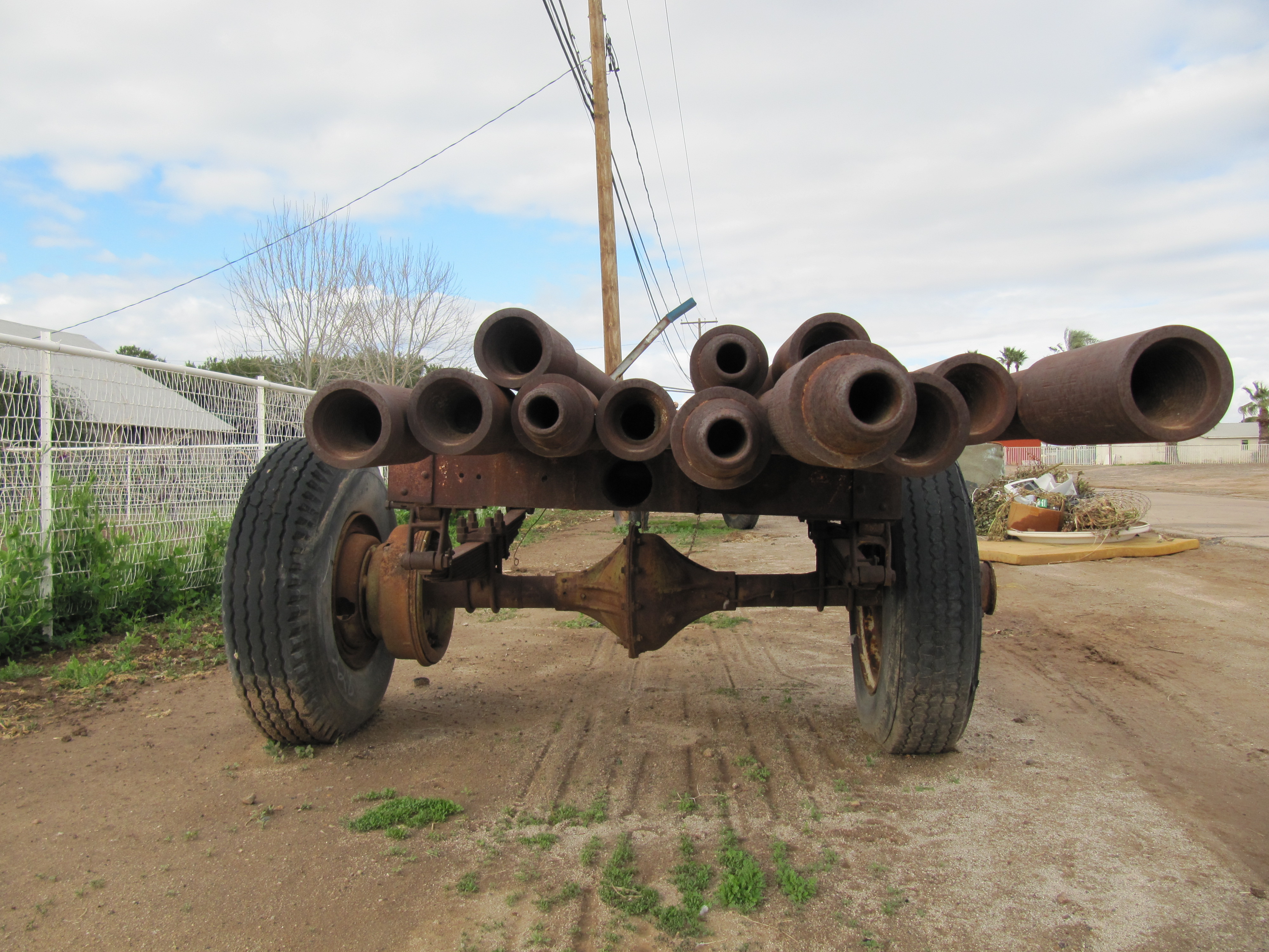 Rusty pipes look at you from atop a flat trailer bed.